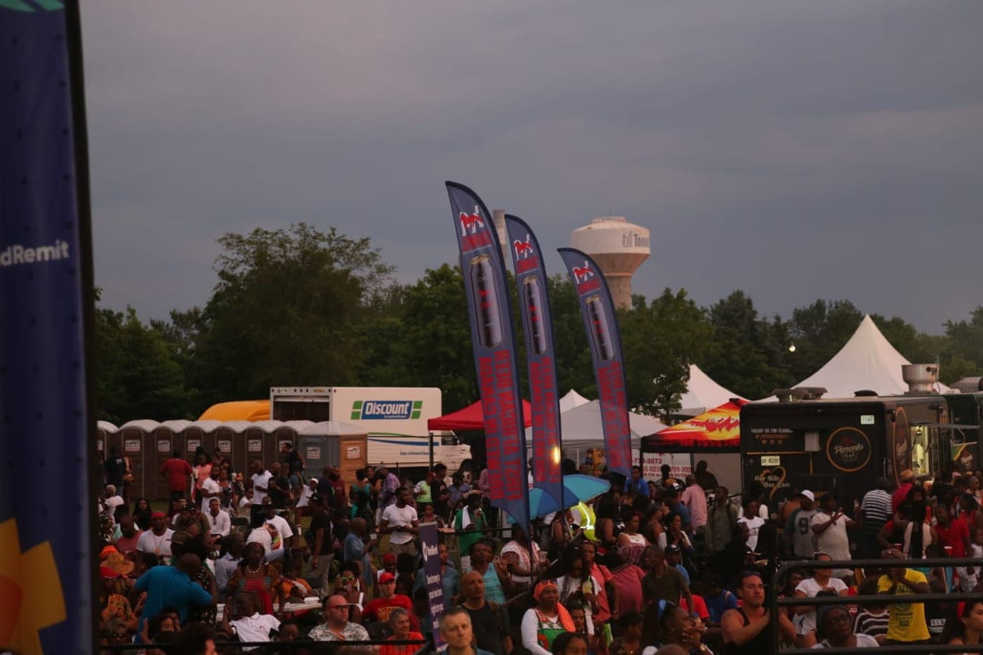 Festival crowd beneath Shawel banner flags at dusk