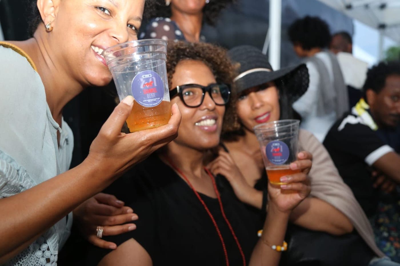 Three friends toasting with cups of Shawel at a festival