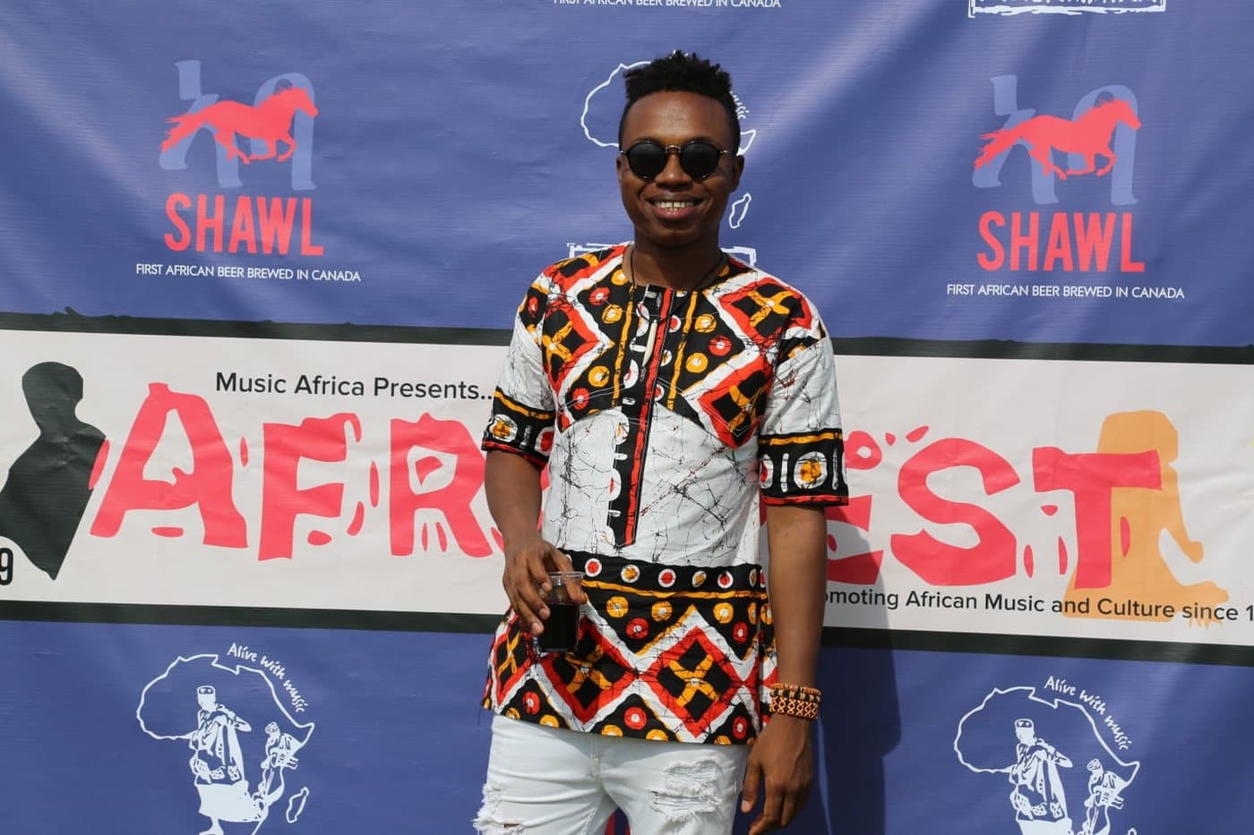 A guest in African print at the Shawel AfroFest step-and-repeat wall