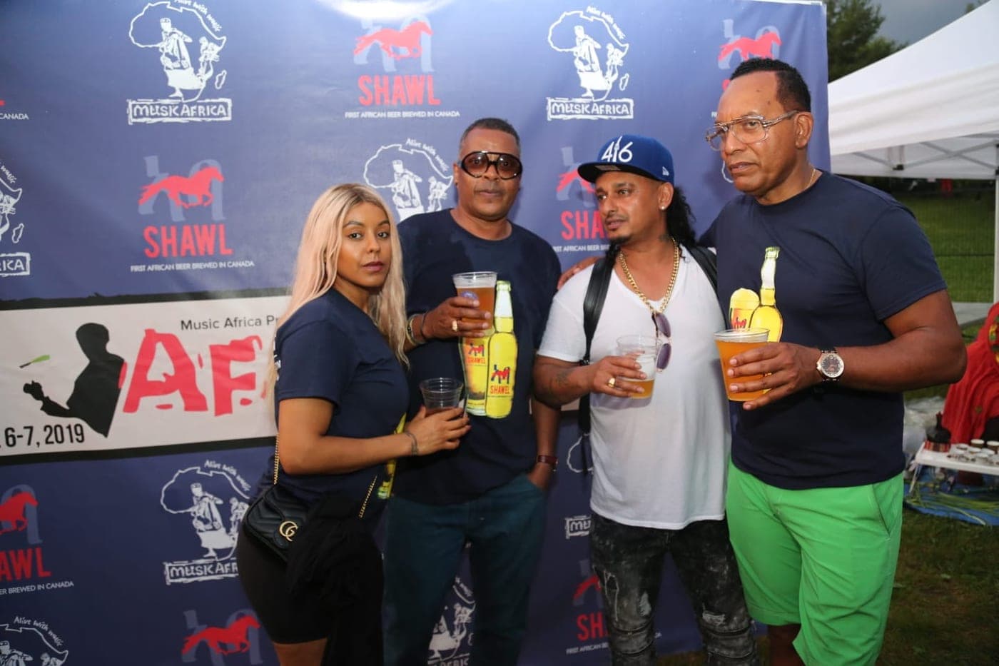 Four friends with Shawel beers in hand at the festival wall
