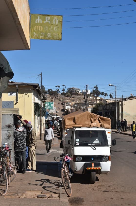 Street life in the Abba Shawl quarter: bicycles, signs, and a loaded truck